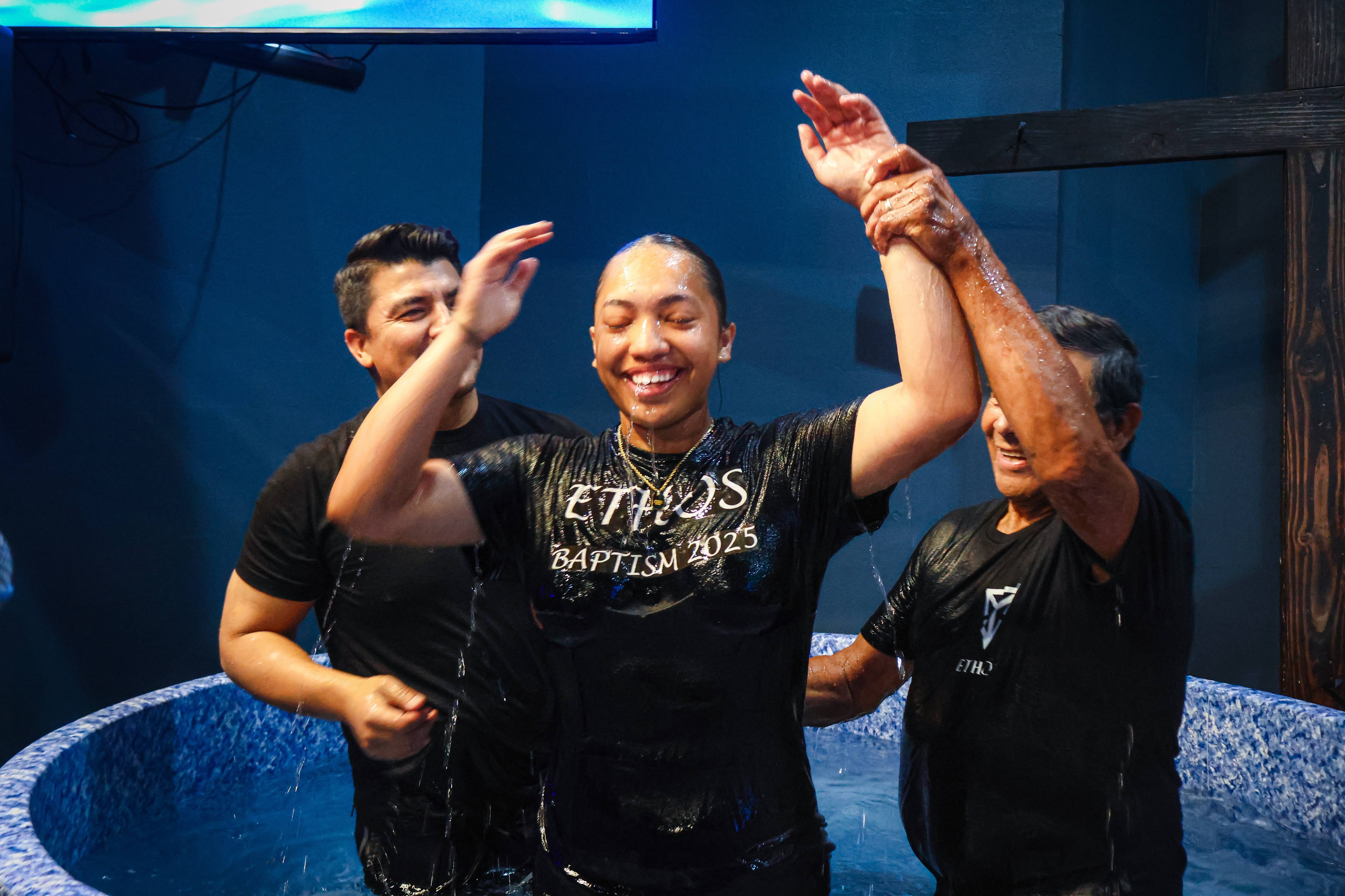 Woman joyfully coming up from baptism waters