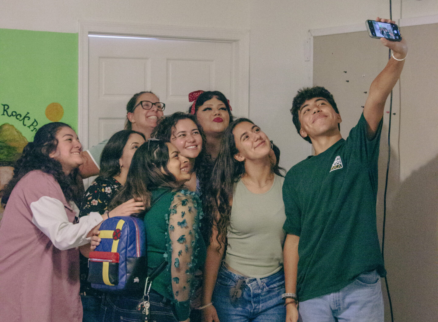 A group of people taking a selfie in a room.